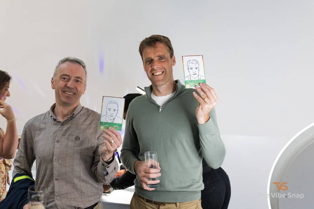 Gentlemen at a party, showing a copy of their faces drawn by the Sketch Bot