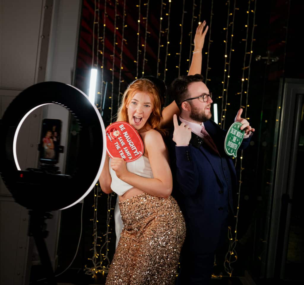 Ladies and gents at a party posing for photos on the 360 booth