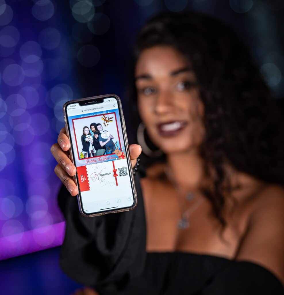 Beautiful woman with curly hair showing her phone with latest photo taken by selfie mirror