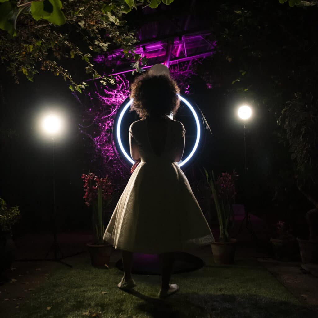 A woman posing in front of The Beauty mirror.