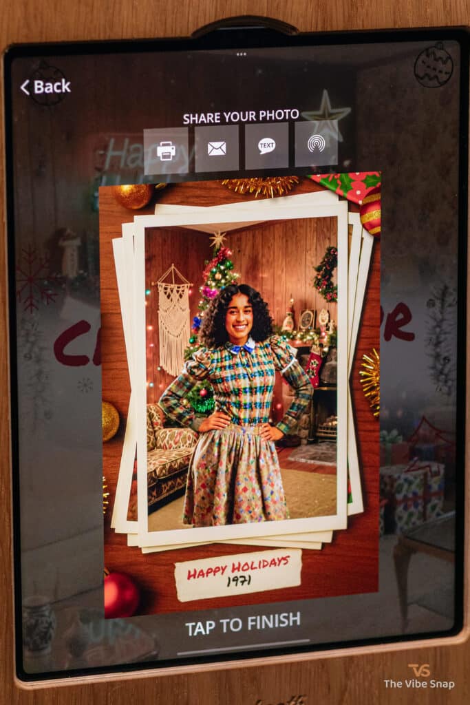 A woman in a plaid dress with a Happy Holidays frame, transformed into a 1971 Christmas theme using a photo booth app, part of the AI Nostalgic Holiday experience