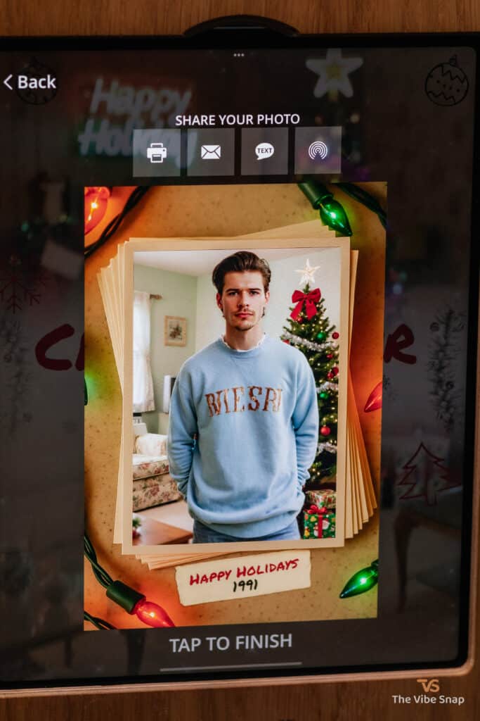 A young man in a light blue shirt with a Happy Holidays frame, transformed into a 1991 holiday scene using a photo booth app, part of the AI Nostalgic Holiday experience