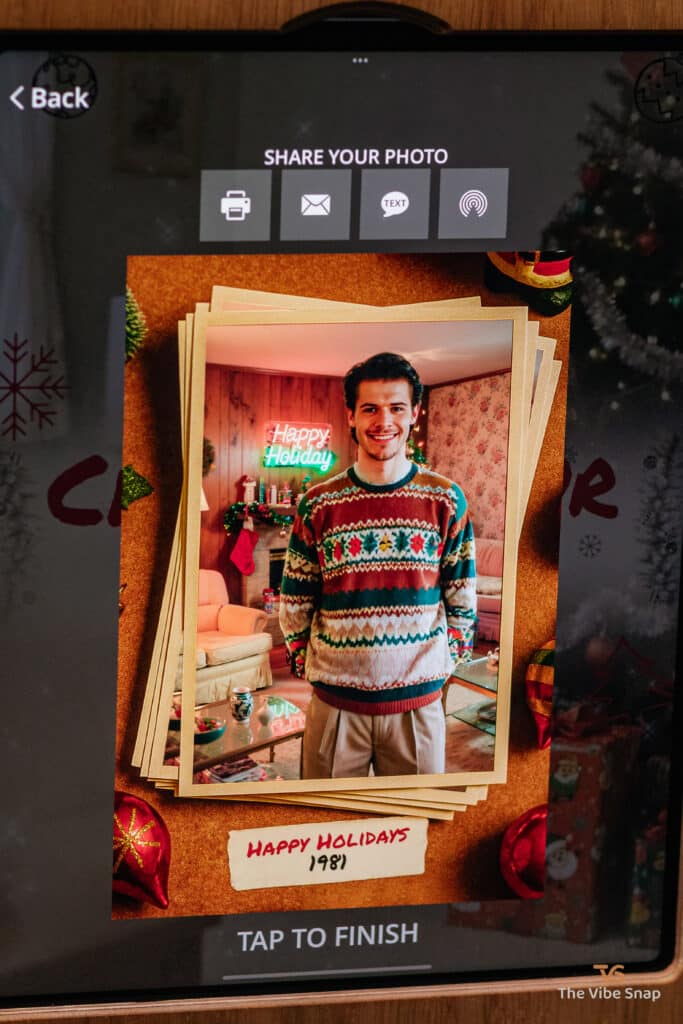 A young man in a reindeer sweater with a Happy Holidays frame, transformed into a 1981 holiday scene using a photo booth app, part of the AI Nostalgic Holiday experience