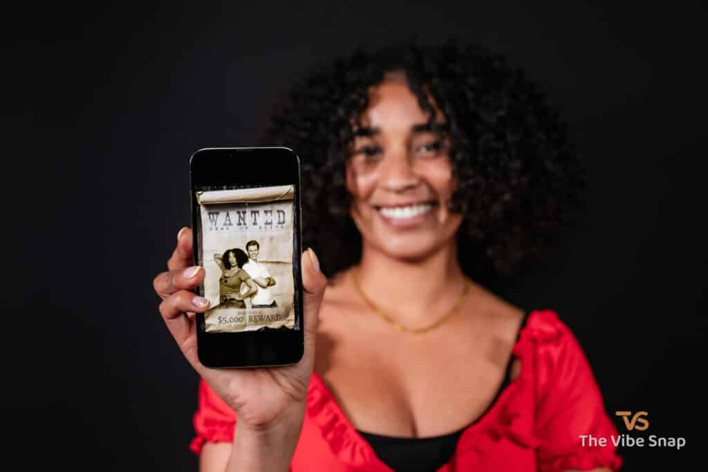 The Wild West Experience - A young woman holding an iphone with wanted poster