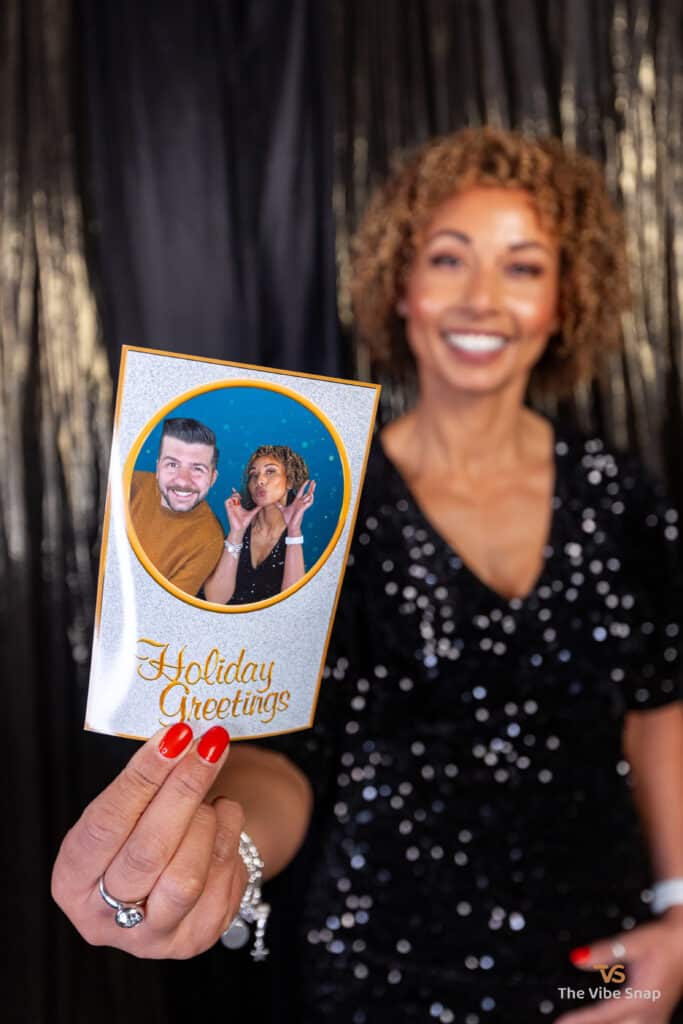 A mixed race lady at Holiday Party showing her holiday greeting card printed on 4x6
