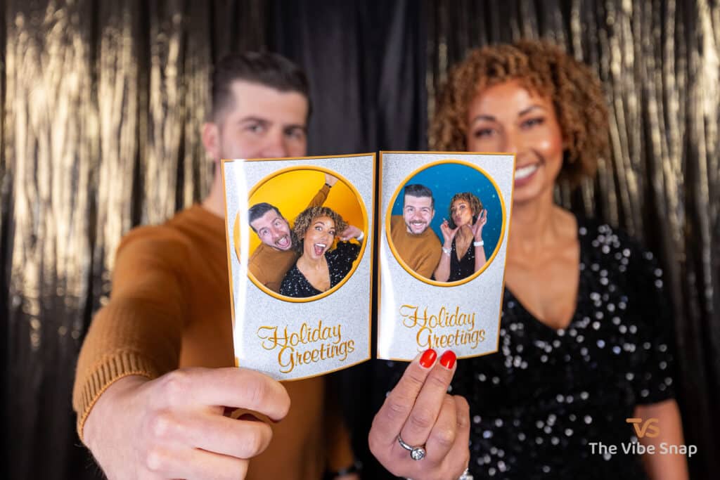 Couple holding printed Holiday Greetings Photos.