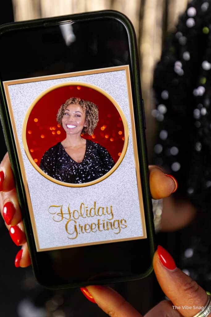 Mixed race lady holding a phone with her holiday greeting photo