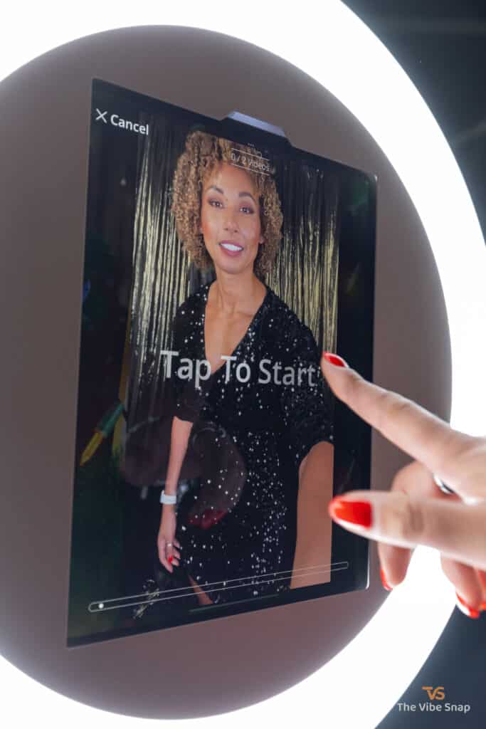 Mixed race lady starting photo booth by tapping the screen