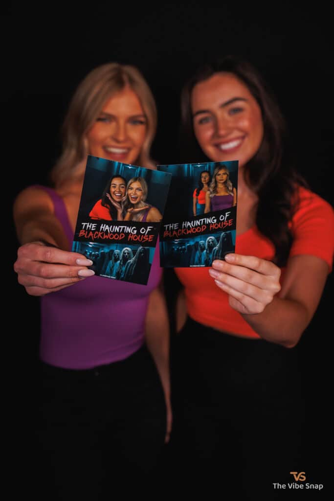 The Haunting of Blackwood House photos in a hands of two girls smiling into a camera