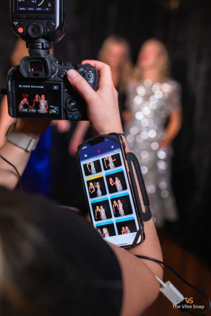 Photographer holding a camera with an iPhone.