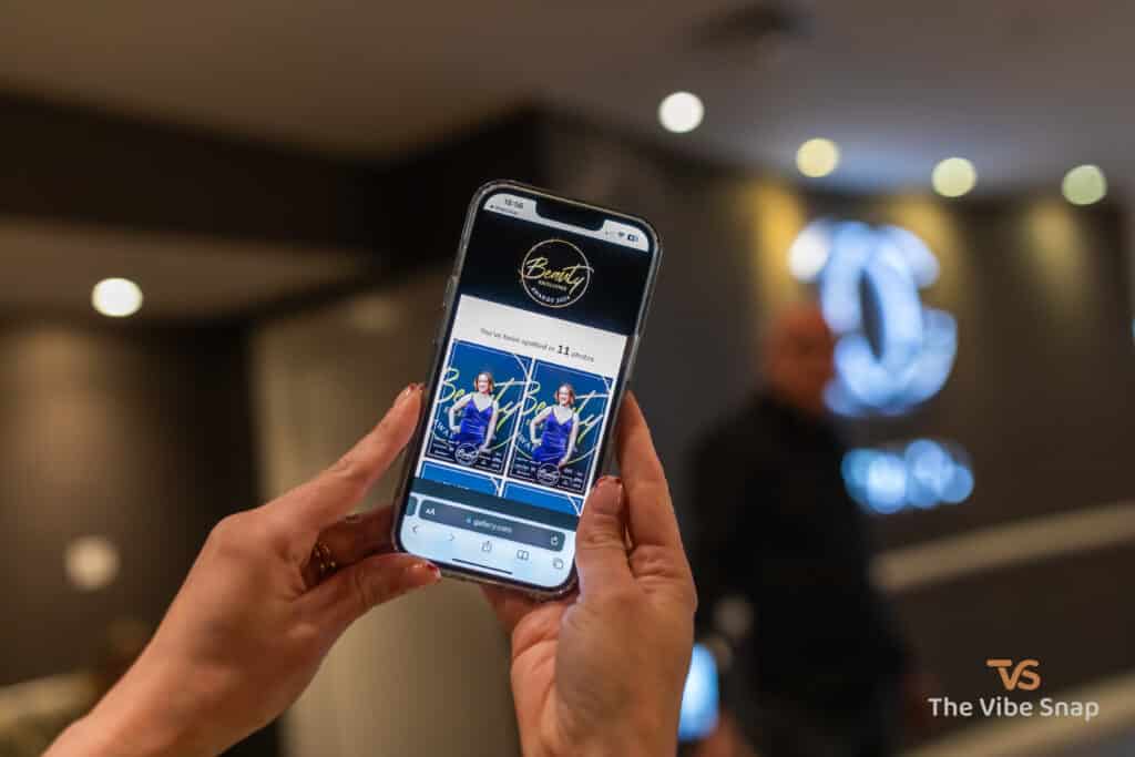 A person holding a phone and showing their personalised gallery from the event